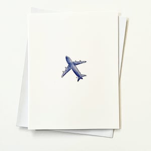 May include: A simple white card with a blue airplane drawn on it.