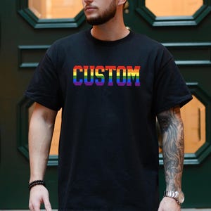 May include: A black t-shirt with the word "CUSTOM" printed in rainbow colors.