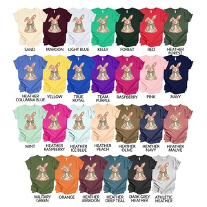 May include: A range of t-shirt colours featuring a floral bunny graphic design. The colours include sand, maroon, light blue, kelly green, forest green, red, heather forest, heather columbia blue, yellow, true royal, team purple, raspberry, pink, navy, mint, heather raspberry, heather ice blue, heather peach, heather olive, heather navy, heather mauve, military green, orange, heather maroon, heather deep teal, dark grey heather, and athletic heather.