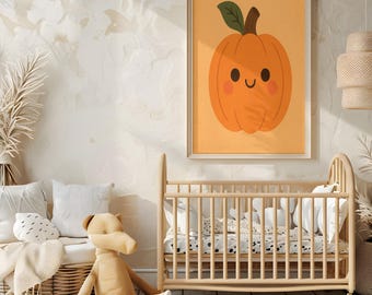 Op de afbeelding: Een ingelijste wandkunstprint met een lachende oranje pompoen met een groene stengel en blad. Het kunstwerk hangt boven een houten wieg in een kinderkamer. Een knuffel en kussens zijn ook zichtbaar.