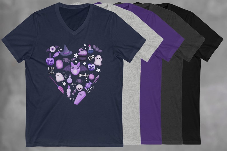 Pu&ograve; includere: Una t-shirt blu navy con scollo a V con un design a forma di cuore viola e bianco che presenta varie icone a tema Halloween, tra cui un fantasma, un pipistrello, un ragno, un cappello da strega, un calderone, una zucca e le parole "Trick or Treat" e "Spooky".