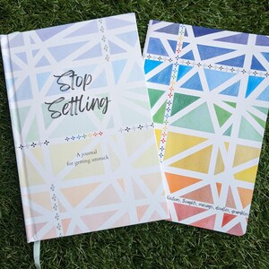 Puede incluir: Dos diarios con coloridos patrones geométricos. El diario de la izquierda tiene el título "Stop Settling" y el texto "A journal for getting unstuck". El diario de la derecha tiene el texto "Westons, thoughts, meanings, doodles, grumbles".