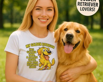 May include: A woman and a golden retriever dog are in a park. The woman is wearing a white t-shirt with a cartoon graphic of a golden retriever and the text "MY GOLDEN RETRIEVER HAS GOLDEN HAIR, A GOLDEN HEART, AND ZERO PERSONAL SPACE". A circular graphic reads "GOLDEN RETRIEVER LOVERS!"