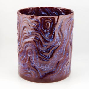 May include: A ceramic planter with a deep burgundy glaze and a swirling blue pattern.