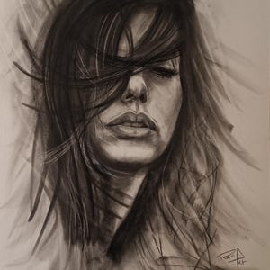 Peut inclure: Un portrait au fusain d'une femme aux longs cheveux sombres balayés sur son visage. L'œuvre est un gros plan du visage de la femme, les yeux fermés et une expression sereine. Le dessin est détaillé, avec des ombres qui créent de la profondeur.