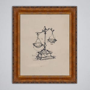 May include: A framed pen and ink drawing of a balance scale. The artwork features a detailed sketch of the scale with two hanging pans, a central support, and a decorative base. The frame is a warm, ornate gold color.