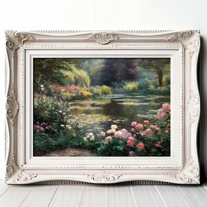 Op de afbeelding: Een ingelijst landschapsschilderij met een serene vijverscène met roze en witte bloemen, weelderig groen en zacht licht. De sierlijke, gebroken witte lijst voegt een klassieke touch toe aan het kunstwerk.