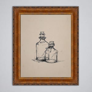 May include: A framed sketch of two glass bottles with cork stoppers. The larger bottle is taller than the smaller one, and both are drawn in black ink. The frame is a warm, ornate gold color, adding a vintage aesthetic.