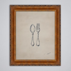 Puede incluir: Una obra de arte enmarcada con un dibujo a pluma y tinta de una cuchara y un tenedor. Los utensilios están representados en un estilo sencillo y elegante sobre un fondo beige. El marco es de color dorado cálido y ornamentado.