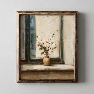 May include: A framed painting depicting a still life. A small vase with white and pink flowers sits on a windowsill. The window frame is dark blue and the painting has a gold frame.