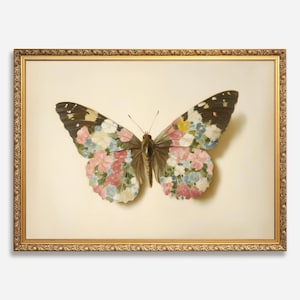 May include: A framed butterfly print. The butterfly has wings with a floral pattern in shades of pink, blue, and yellow. The frame is gold with ornate detailing. The background is a light beige.