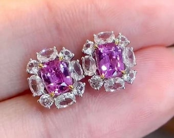 Può includere: Un paio di orecchini con una pietra preziosa quadrata rosa circondata da pietre preziose bianche più piccole.