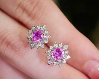 Può includere: Un paio di orecchini in zaffiro rosa con un design floreale. Ogni orecchino presenta uno zaffiro rosa di forma ovale circondato da un alone di diamanti più piccoli.