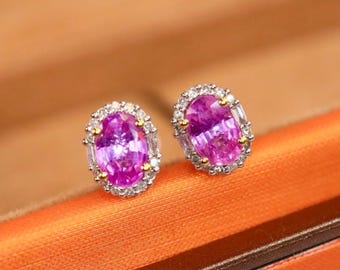 Può includere: Un paio di orecchini ovali in zaffiro rosa con un alone di piccoli diamanti incastonati in oro bianco.
