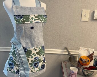 Are you blue right now? Brighten up with this light blue apron adorned with blue roses. Detail stitching on straps are navy rose buds.