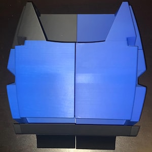 May include: A blue and black plastic storage box with a hinged lid. The box is divided into two sections.