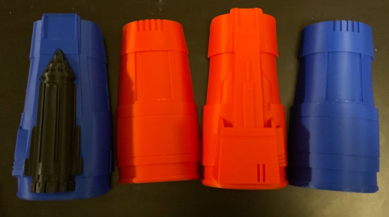 Puede incluir: Cuatro tubos de pl&aacute;stico impresos en 3D, dos azules y dos naranjas. Los tubos azules tienen un detalle negro en la parte delantera.