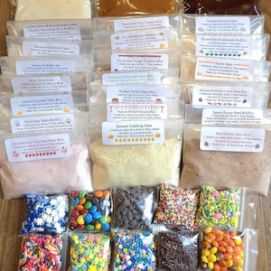 May include: An assortment of individually packaged baking mixes and colorful sprinkles. The mixes include various cake and brownie flavors, such as chocolate chip, rainbow confetti, and red velvet. The sprinkles come in various shapes and colors.