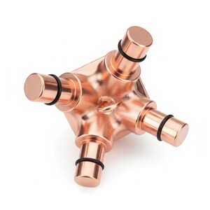 May include: A metallic copper-colored geometric object featuring a central square-based body with four protruding cylindrical arms. Each arm is capped with a flat end and features a thin black rubber O-ring positioned near the base of the cylinder.
