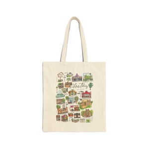 Peut inclure: Un sac fourre-tout beige avec une illustration colorée de bâtiments et de monuments de Los Feliz, en Californie. Le texte "Los Feliz" est écrit en cursive noire.
