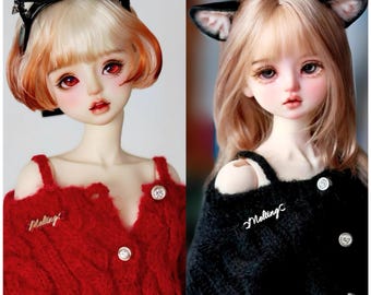 May include: Two dolls with long blonde hair wearing red and black sweaters with the word "Melting" embroidered on them. The dolls are wearing cat ears and have red and brown eyes.