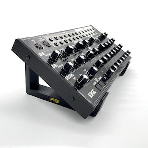 May include: Black synthesizer with a stand. The synthesizer has a variety of knobs and buttons, including a sequencer and a filter. The stand is made of black wood and has a yellow logo that says "PS".