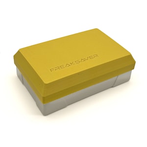 May include: A yellow plastic box with the text "FREAKSAVER" embossed on the top.