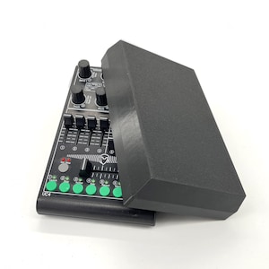 May include: A black UC4 MIDI controller with a matching black cover. The controller features knobs, faders, and buttons in various colors. The device is designed for music production and DJing.