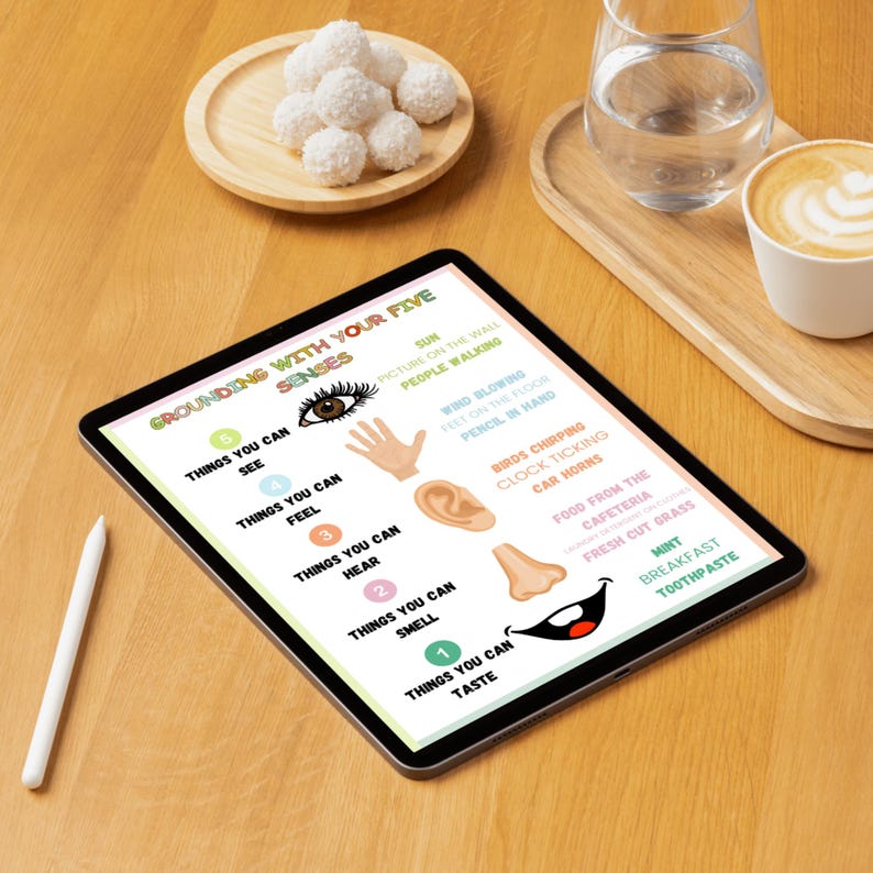 May include: A digital tablet displaying a grounding exercise using the five senses. The exercise lists things you can see, feel, hear, smell, and taste.  Examples include the sun, wind blowing, birds chirping, and fresh cut grass.