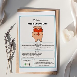 May include: A greeting card with the text "Oxytocin Hug a Loved One" and an illustration of a bear holding a heart. The card includes information about the benefits of hugging and how to do it. The card is on a brown envelope.