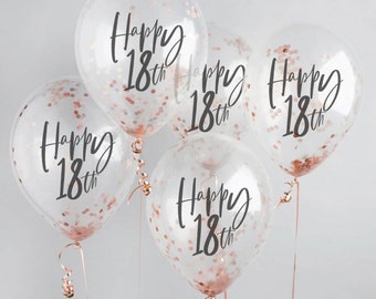 May include: Five clear balloons with rose gold confetti and the text "Happy 18th" printed on each.