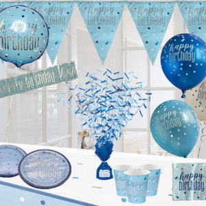 May include: Blue and silver happy birthday party decorations including balloons, plates, cups, napkins, a banner, and confetti.