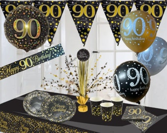 May include: Black and gold 90th birthday party decorations. The set includes balloons, a banner, table cover, plates, cups, napkins, and a centerpiece. The balloons feature the number 90 and the text "happy birthday".