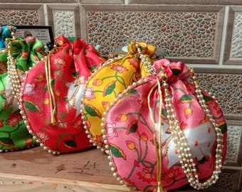 May include: Four drawstring bags with floral patterns and pearl trim. The bags are in shades of blue, green, red, and pink.