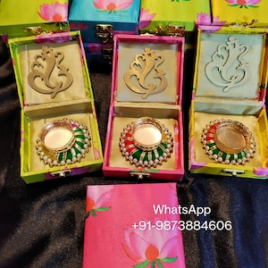 Op de afbeelding: Set van kleine, kleurrijke geschenkdozen met bloemenmotieven. Elke doos heeft een scharnierend deksel en een klein, decoratief metalen uitsnijding erin. De dozen zijn gevoerd met een zacht, wit materiaal. De dozen zijn perfect voor het bewaren van kleine cadeautjes of snuisterijen. WhatsApp +91-9873884606