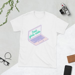 May include: White t-shirt featuring a graphic of a laptop with the text "Cool girls code" on the screen.