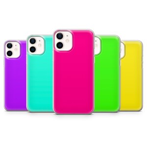 Peut inclure: Cinq coques de téléphone colorées alignées. Les coques sont dans des tons vifs de violet, turquoise, rose vif, vert et jaune. Chaque coque a une bordure transparente et une découpe pour l'appareil photo.