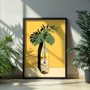 Könnte beinhalten: Gerahmter Kunstdruck mit gelbem Hintergrund, einer Club-Mate-Flasche und grünen Blättern. Die Flasche ist gelb mit einem Etikett. Das Kunstwerk wird in einem schwarzen Rahmen präsentiert und lehnt an einer weißen Wand.