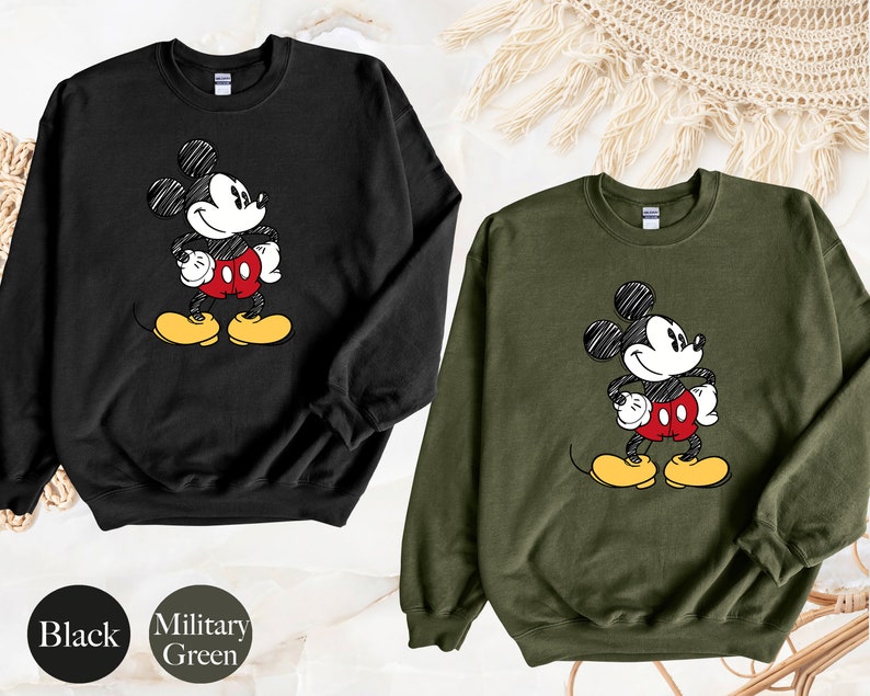 May include: Black and military green sweatshirts with a cartoon drawing of Mickey Mouse on the front.
