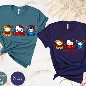 May include: Two t-shirts, one heather deep teal and one navy, featuring a cartoon design. The design includes three characters, Hello Kitty and Stitch, with the word "LOVE" in red. The navy shirt has the text "CUSTOM TEXT" below the word "LOVE".