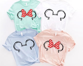 May include: Four t-shirts with different designs featuring Mickey Mouse ears and a red bow with white polka dots. The shirts are in various colors, including light blue, pink, white, and green.