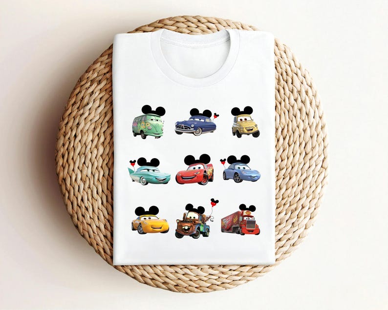 Puede incluir: Camiseta blanca con nueve coches de dibujos animados coloridos con orejas de Mickey Mouse. Cada coche tiene un dise&ntilde;o y un color diferente.