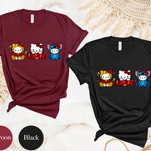 May include: Maroon and black t-shirts featuring cartoon characters in costumes with the word "LOVE" in red. The characters include a tiger, Hello Kitty, and Stitch. The shirts are short-sleeved.