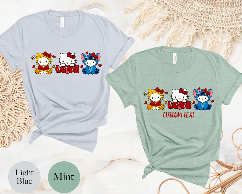 May include: Light blue and mint green t-shirts featuring cartoon characters. The light blue shirt has a bee-themed Hello Kitty, Hello Kitty with the word "LOVE", and Stitch. The mint green shirt has the text "CUSTOM TEXT".