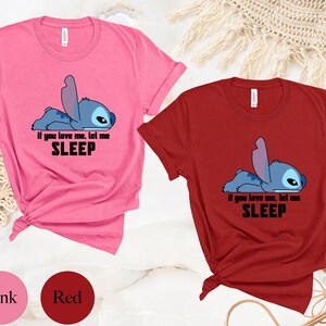 K&ouml;nnte beinhalten: Zwei T-Shirts mit einem blauen Stitch-Charakter aus Lilo & Stitch. Das rosa T-Shirt sagt "Wenn du mich liebst, lass mich SCHLAFEN". Das rote T-Shirt sagt dasselbe.