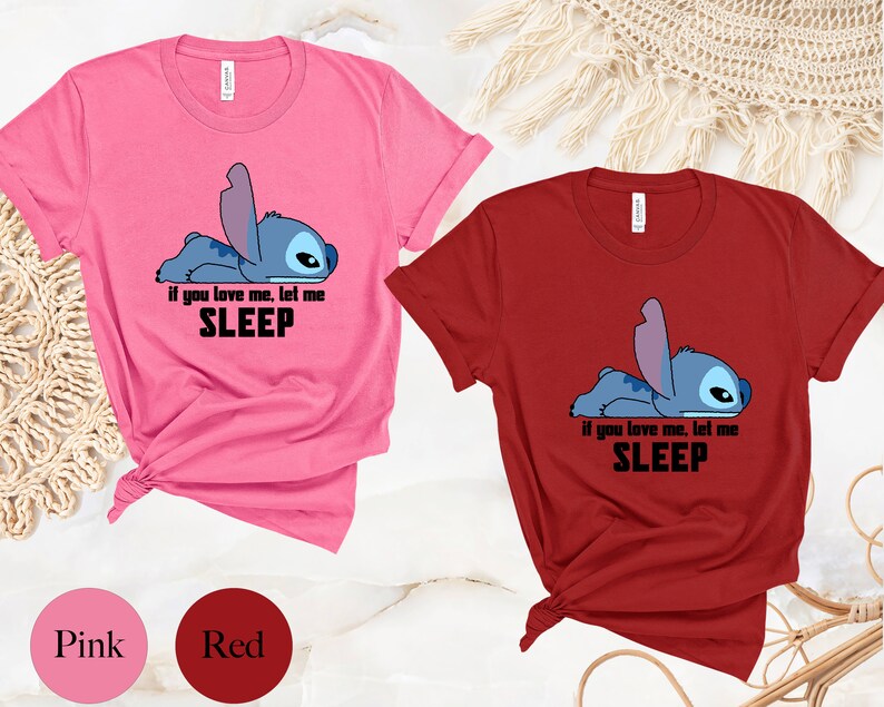 K&ouml;nnte beinhalten: Zwei T-Shirts mit einem blauen Stitch-Charakter aus Lilo & Stitch. Das rosa T-Shirt sagt "Wenn du mich liebst, lass mich SCHLAFEN". Das rote T-Shirt sagt dasselbe.