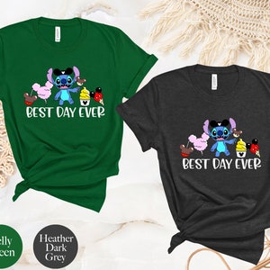 May include: Two t-shirts with a blue Stitch character wearing a Mickey Mouse hat and holding a pink cotton candy, a brown Mickey Mouse ear, a yellow ice cream cone, and a red Mickey Mouse ear. The text "Best Day Ever" is printed below the character. The t-shirt on the left is Kelly green and the t-shirt on the right is heather dark grey.