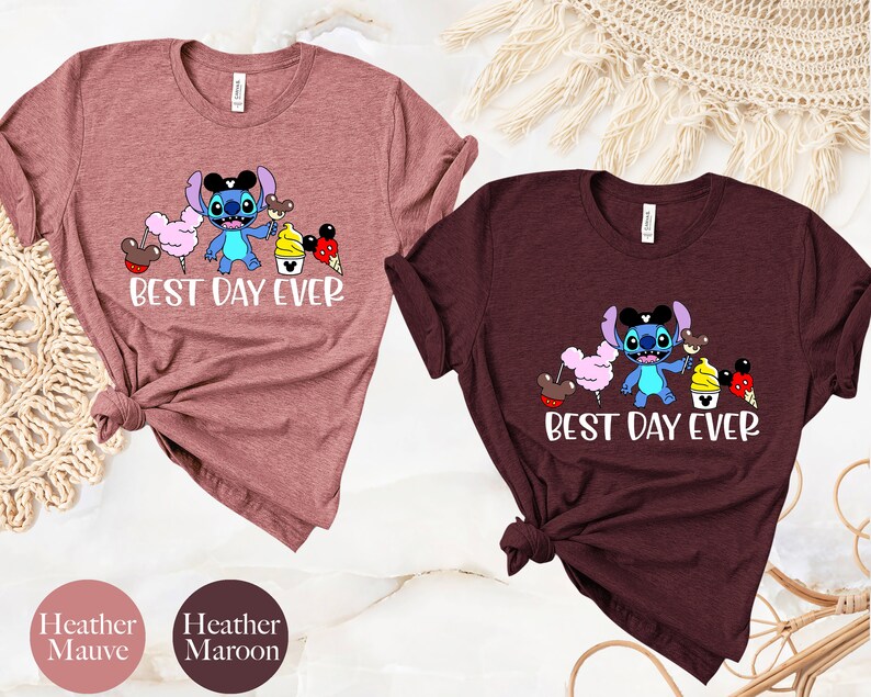 May include: Two t-shirts with a blue Stitch character from Lilo & Stitch holding a Mickey Mouse ice cream cone and other Disney treats. The text on the shirts reads "Best Day Ever". The shirts are available in heather mauve and heather maroon.