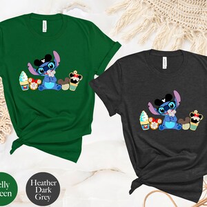 Pode incluir: Duas camisetas, uma verde Kelly e outra cinza escuro mesclado, cada uma com um gr&aacute;fico de um personagem de desenho animado azul com &oacute;culos e gravata borboleta, rodeado de sobremesas. As camisetas s&atilde;o de manga curta.