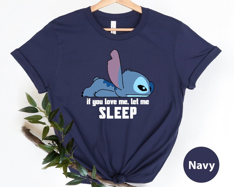 K&ouml;nnte beinhalten: Ein marineblaues T-Shirt mit einer Zeichentrickfigur Stitch aus Lilo & Stitch. Der Text auf dem Shirt lautet "Wenn du mich liebst, lass mich schlafen."